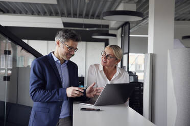 Geschäftskollegen tauschen Ideen aus und arbeiten am Laptop im Büro - RBF08707