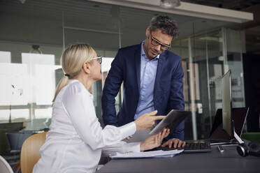 Geschäftskollegen diskutieren über Tablet-PC im Büro - RBF08715