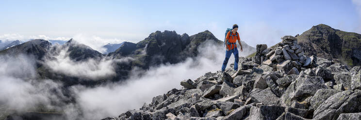 Woman with backpack walking on rocky mountain - ALRF01841