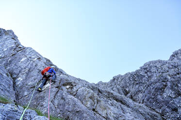 Mann mit Seil klettert auf felsigen Berg - ALRF01843