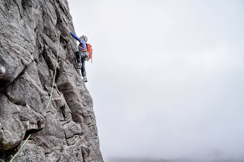 Man with backpack climbing rocky mountain - ALRF01844