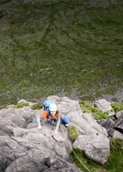 Frau mit Helm klettert auf felsigen Berg - ALRF01846