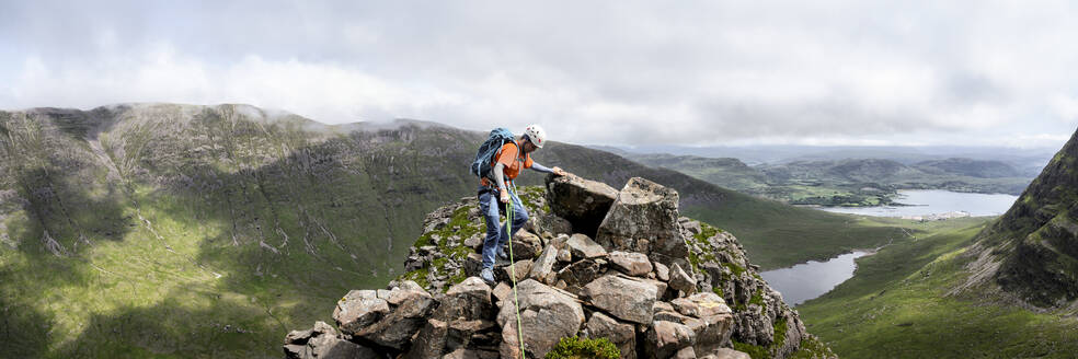 Frau mit Helm beim Klettern auf einem felsigen Berg - ALRF01847