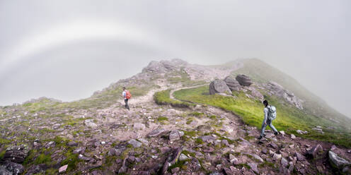 Man and woman walking together with backpack on rocky mountain - ALRF01851