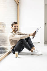 Young man with tablet PC sitting at home - PESF03552