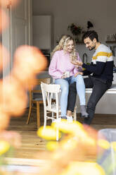 Woman reading palm of boyfriend sitting on table - PESF03565