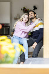 Smiling woman with eyes closed sitting with boyfriend at home - PESF03568