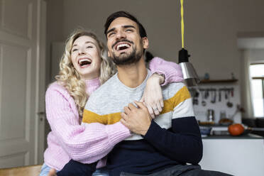 Young couple laughing together at home - PESF03577