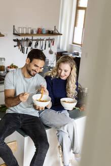 Lächelndes Paar isst Nudeln in der Küche - PESF03589
