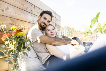 Sich umarmendes Paar auf der Terrasse ruhend - PESF03648