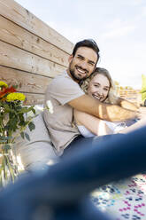 Happy man with girlfriend enjoying on terrace - PESF03650