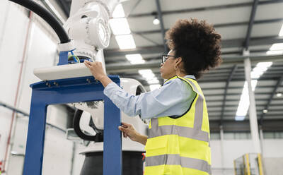 Techniker bei der Untersuchung einer Roboterarm-Maschine in einer Fabrik - JCCMF05759