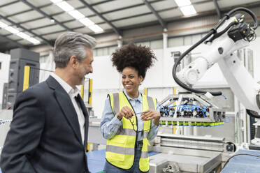 Happy businessman with engineer in factory - JCCMF05779