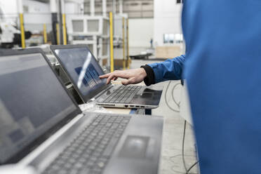 Hand eines Ingenieurs mit Laptop in einer Fabrik - JCCMF05797