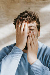 Man with eyes closed covering face with hands - MIMFF00783