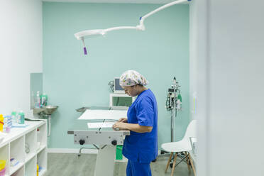 Mitarbeiter des Gesundheitswesens bei der Prüfung eines Dokuments in einer Tierklinik - MRRF01947