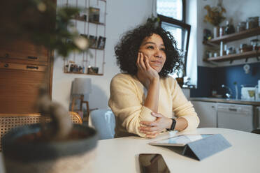 Woman sitting with tablet PC sitting at dining table - JOSEF07696