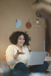 Lächelnde Frau bei einem Videogespräch auf dem Laptop zu Hause - JOSEF07709