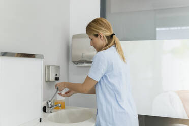 Zahnärztin in Uniform beim Händewaschen in einer Zahnklinik - JCCMF05804