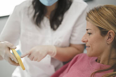 Zahnarzt erklärt Patientin über Mobiltelefon in der Zahnklinik - JCCMF05862