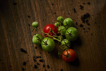 Rote und grüne Tomaten auf einer Holzunterlage liegend - DIKF00665