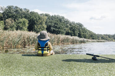 Kleiner Junge sitzt am Flussufer an einem sonnigen Tag - ACTF00183