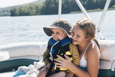Niedlicher kleiner Junge sitzt auf dem Schoß einer Frau auf einem Flussboot - ACTF00187