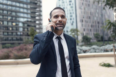 Businessman talking on phone outdoors - JSRF01944