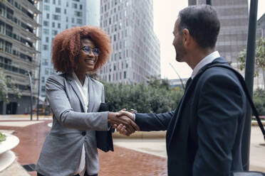 Two business colleagues shaking hands outdoors - JSRF01955