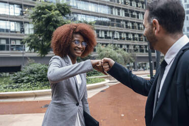 Two business colleagues fist bumping outdoors - JSRF01961