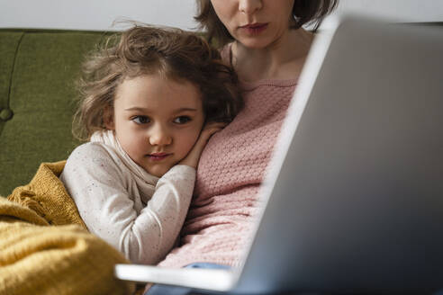 Mutter mit kranker Tochter benutzt Laptop zu Hause - DIGF17742