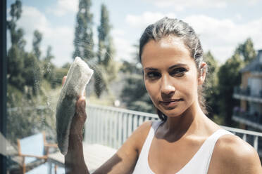 Woman cleaning glass window on sunny day - JOSEF07972