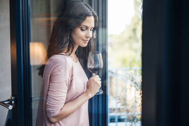 Beautiful woman with wineglass seen through glass window - JOSEF08008