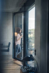 Frau mit Weinglas am Fenster stehend zu Hause - JOSEF08009