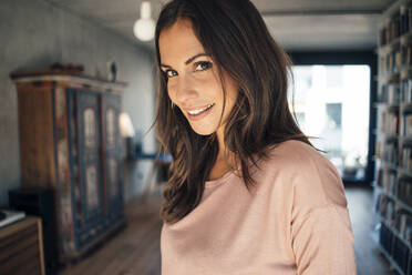 Smiling beautiful woman with brown hair at home - JOSEF08028