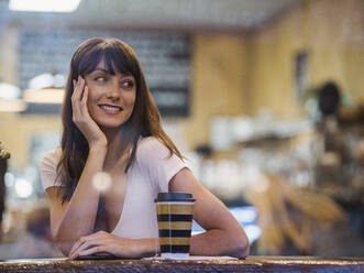 Smiling woman sitting in cafe - TETF01599