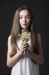 Studio-Porträt eines Mädchens (10-11) mit einem Strauß Wildblumen - TETF01624