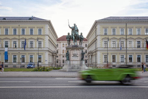 Deutschland, Bayern, München, Auto passiert Statue von Ludwig I. von Bayern vor dem Bayerischen Staatsministerium der Finanzen und des Innern - MAMF02075
