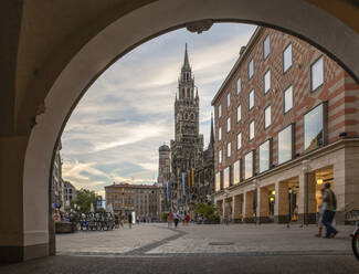 Deutschland, Bayern, München, Ansicht des Marienplatzes mit Bogen im Vordergrund und Neuem Rathaus im Hintergrund - MAMF02081