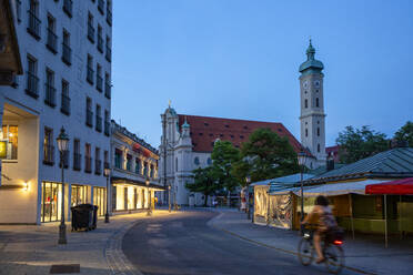 Deutschland, Bayern, München, Viktualienmarkt in der Abenddämmerung mit Heilig-Geist-Kirche im Hintergrund - MAMF02088