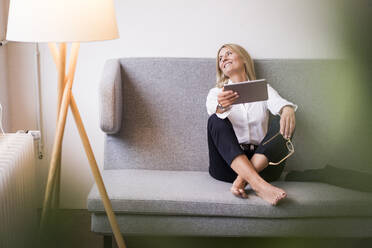 Smiling businesswoman with tablet computer in office - JOSEF08059