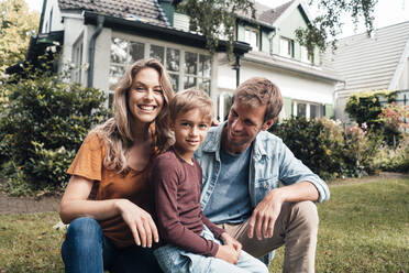 Smiling blond woman with man and son at backyard - JOSEF08086