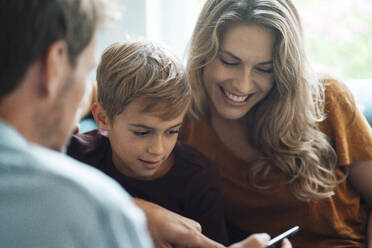 Mann teilt Smartphone mit Sohn und Frau zu Hause - JOSEF08088