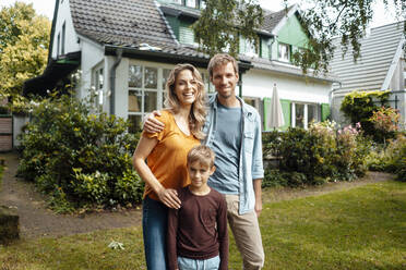 Happy father and man standing with son at backyard - JOSEF08104