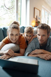 Smiling woman with man and son watching video on laptop at home - JOSEF08174