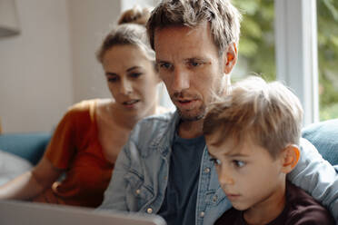 Family sharing laptop together at home - JOSEF08259