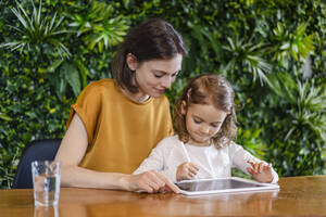 Smiling mother helping daughter at home - DIGF17760