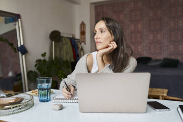 Thoughtful freelancer with laptop working at home - BSZF01981