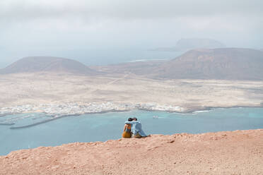Ein Paar entspannt sich auf der Spitze einer Klippe in Mirador del Rio, Lanzarote. - CAVF95816
