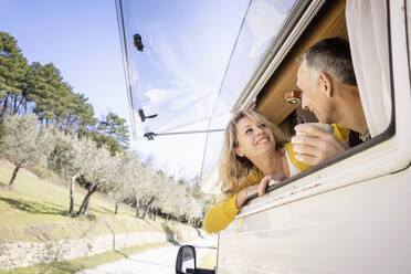 Älteres Paar, das sich unterhält und sich an ein Wohnmobilfenster lehnt - EIF03522